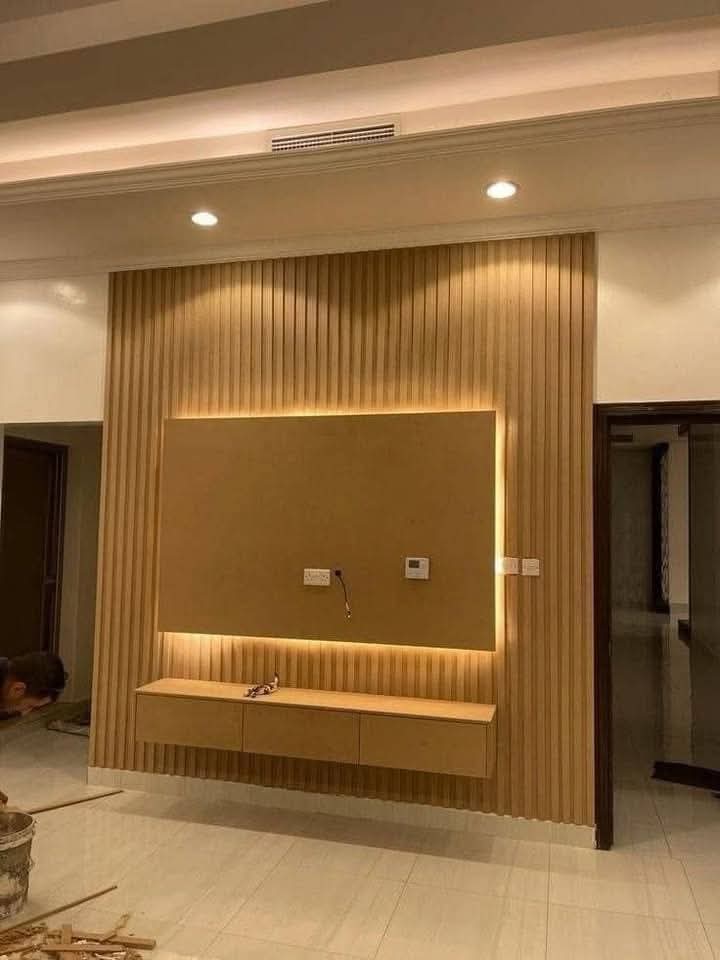 TV feature wall with built-in cabinetry and concealed lighting in a Doha living room (view 6)
